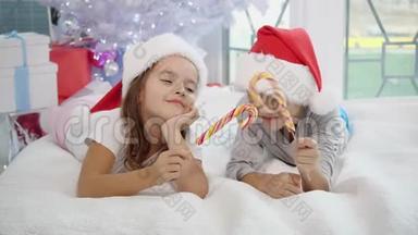 温暖的圣诞节气氛，在这种气氛中，快乐的姐姐和哥哥玩糖果棒，模仿剑战。 `姐姐